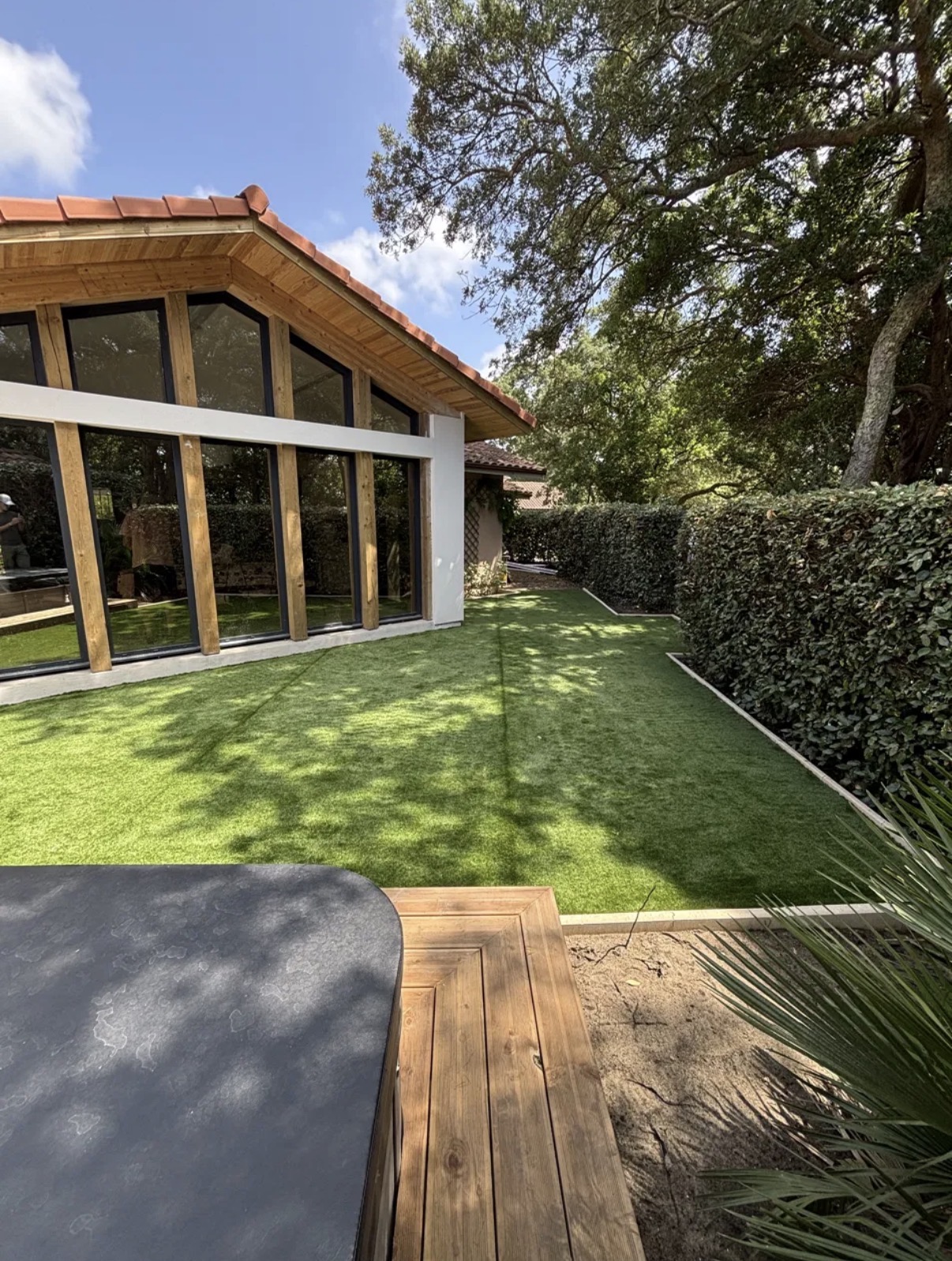 Gazon synthétique posé en tour de maison, rives nettes le long de la façade